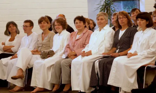 Menschen in weißen Gewändern, vielleicht bei einer Taufe. Sie sind Teil einer Gemeinschaft, die sich als Baptisten versteht.