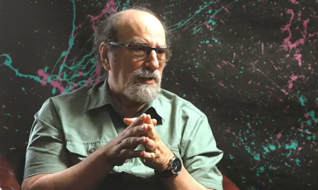Ein Mann mit Brille und Bart, der nachdenklich seine Hände faltet. Er ist einer der bekannten Agnostiker, die über Glauben und Zweifel sprechen.