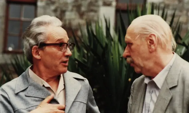 Zwei Männer im Gespräch, einer mit Brille, der andere mit Schnurrbart. Vielleicht Paul Ricoeur, der einem Kollegen seine Gedanken erklärt.