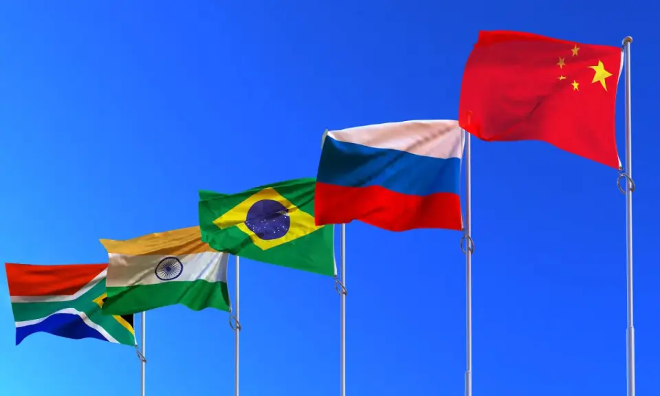 Fünf Flaggen (Südafrika, Indien, Brasilien, Russland, China) wehen im Wind. Die BRICS-Bedeutung wird durch diese Länder repräsentiert, die eine wachsende globale Rolle spielen.