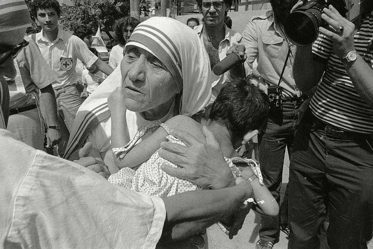 Mutter Teresa tröstet ein Kind. Sie hat ihr Leben der Hilfe für die Armen und Kranken gewidmet.
