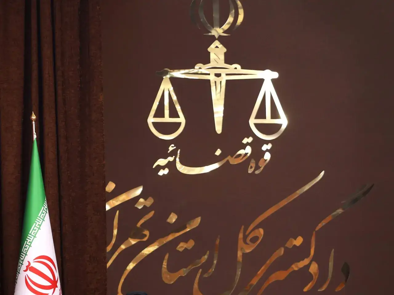 Iran: Justitia-Symbol und Flagge. Die Debatte um die Todesstrafe in Iran ist komplex.