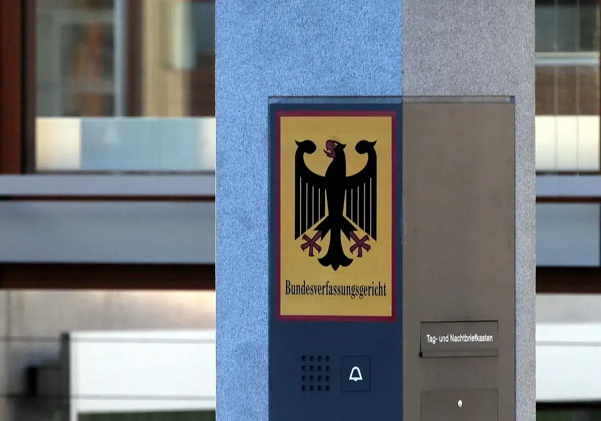 Schild des Bundesverfassungsgerichts, das an Artikel 19 GG erinnert. Ein Adler auf gelbem Grund, darunter der Schriftzug.
