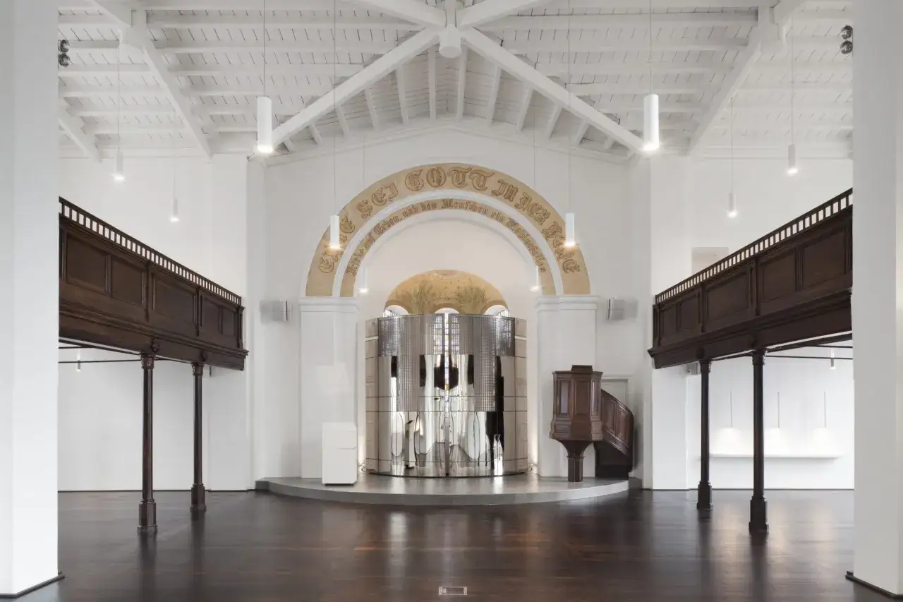 Modernes Interieur einer reformierten Kirche mit Holzbalkonen, einem glänzenden Altar und einer Kanzel.