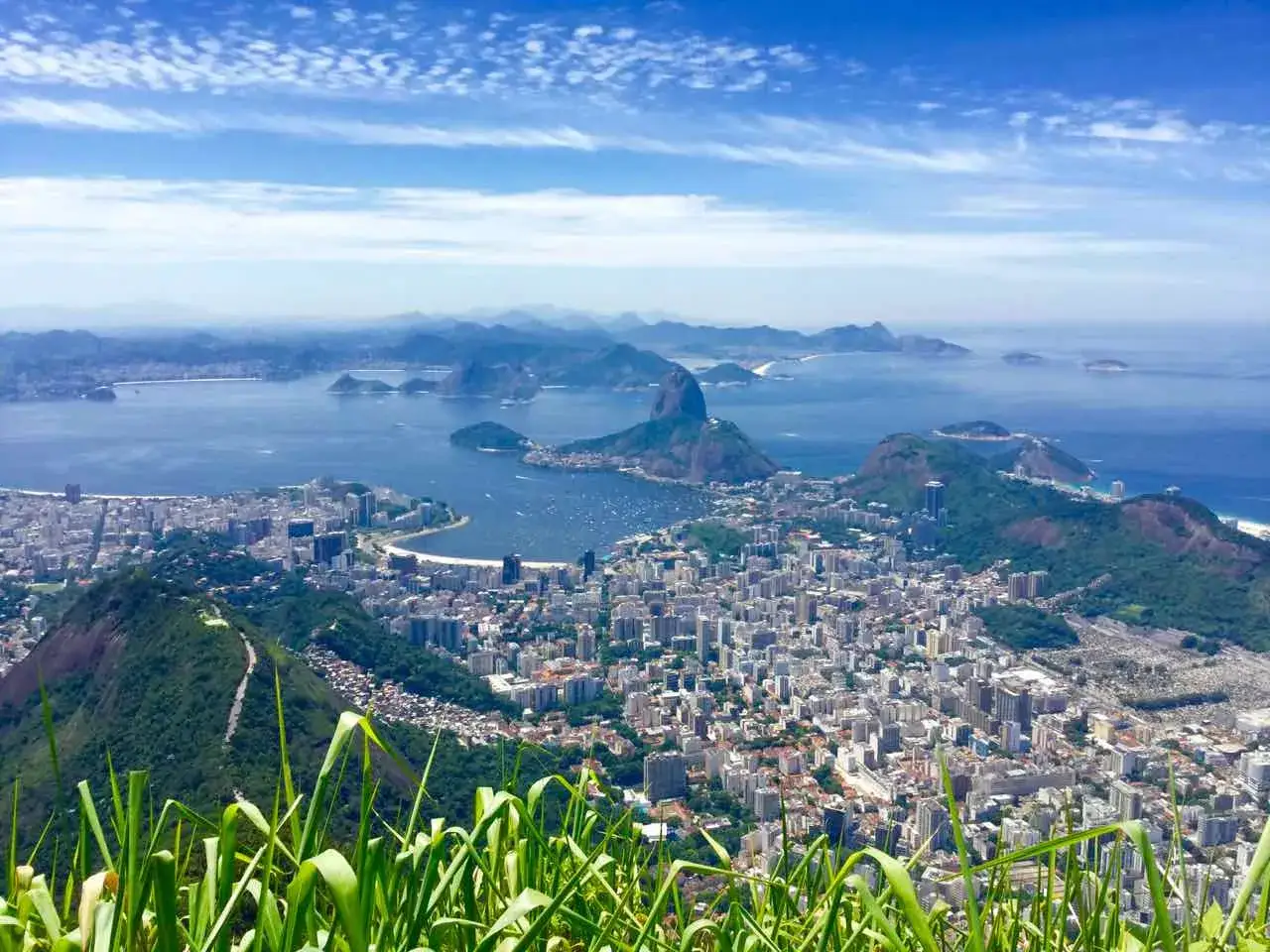 Blick auf Rio de Janeiro mit dem Cristo Redentor in der Ferne, umgeben von Bergen und dem Meer.
