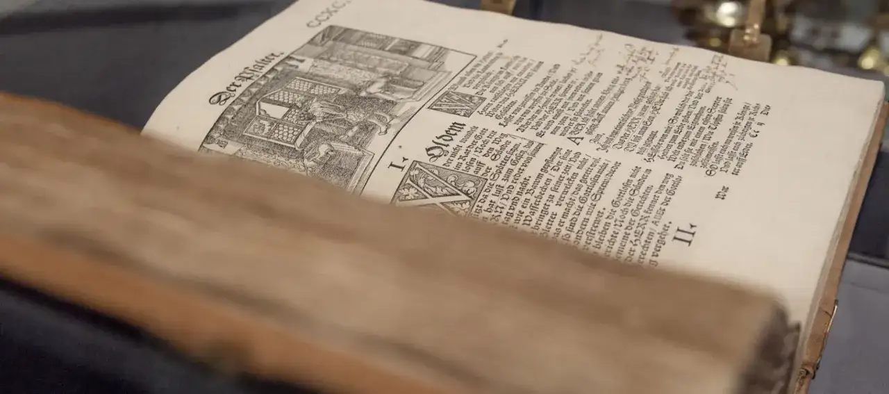 Alte Martin Luther Bibel mit Holzschnitt. Der Text ist in Frakturschrift.