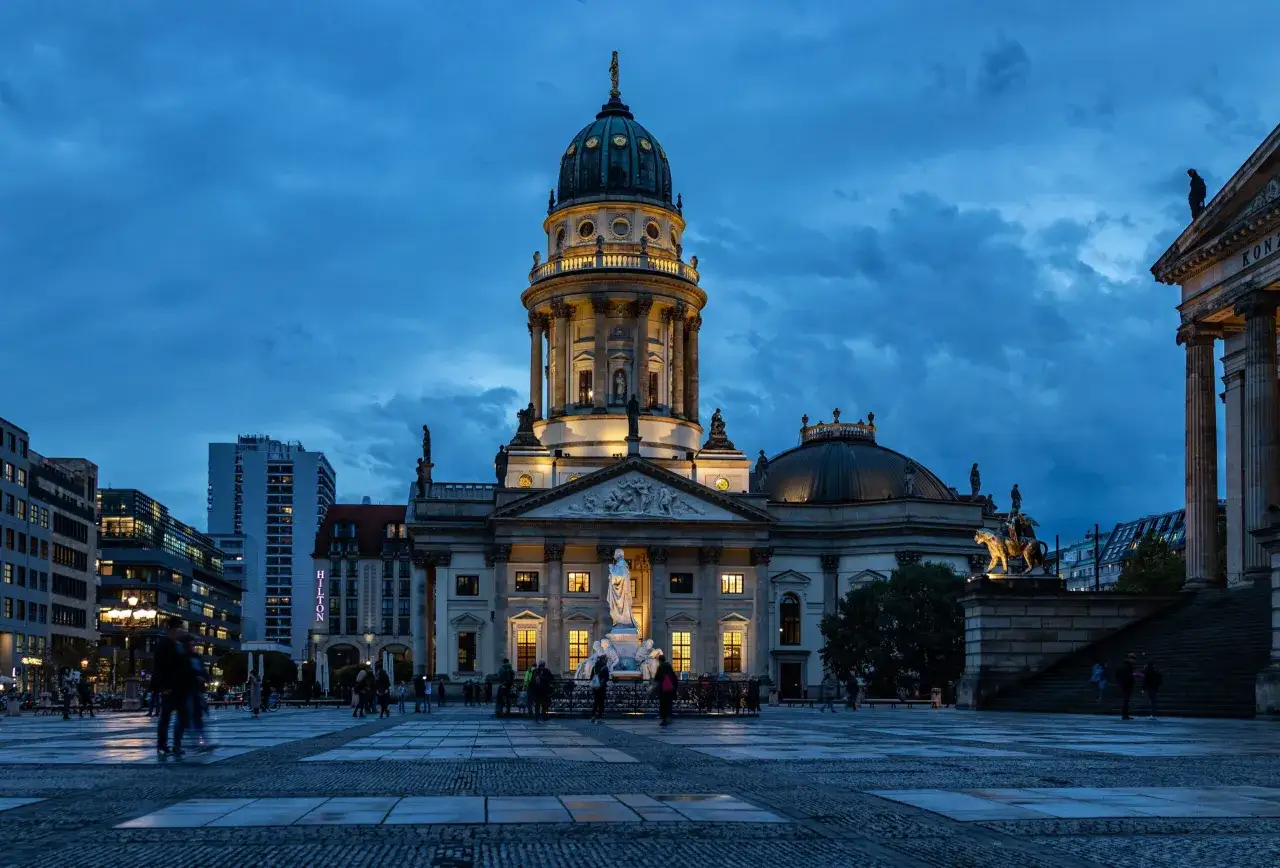 Der Gendarmenmarkt in Berlin bei Dämmerung, ein Ort, der an die Hugenotten erinnert.