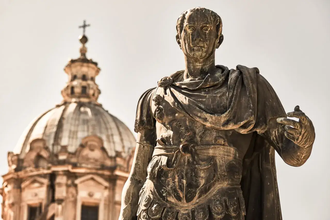 Bronzestatue eines römischen Kaisers vor einer Kuppel. Ein Symbol für das lateinisch Recht und die Ewige Stadt.