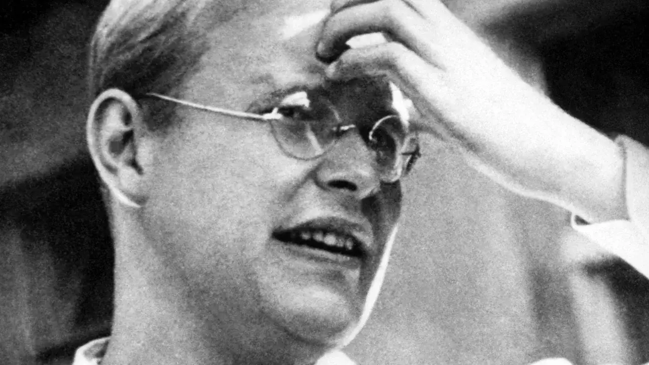 Porträt eines nachdenklichen Mannes mit Brille, der sich an die Stirn fasst. Erinnert an die Frage: wer war Dietrich Bonhoeffer?
