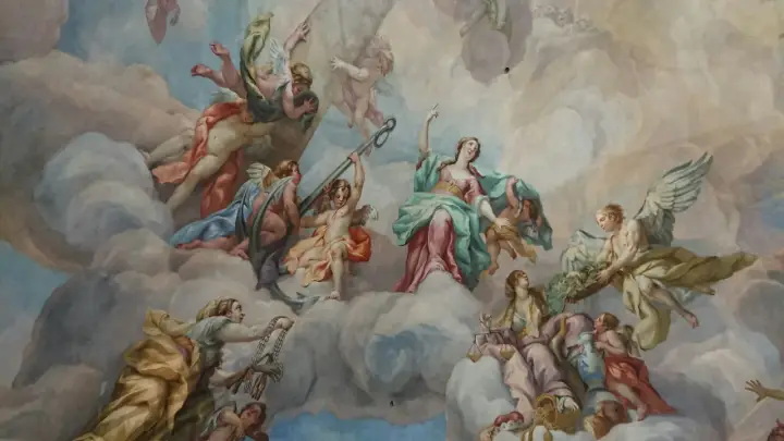 Deckenmalerei mit vielen geflügelten Wesen, die wie engel echt wirken, umgeben von Wolken und himmlischen Lichtern.