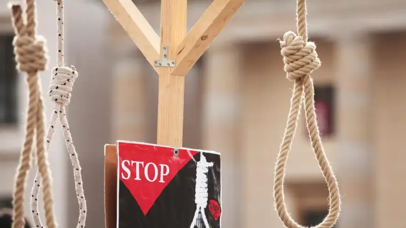 Galgenstricke und ein "STOP"-Schild symbolisieren die Todesstrafe im Iran.